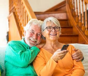 couple-of-two-happy-seniors-sitting-on-the-sofa-at-DKW7W86-1.jpg
